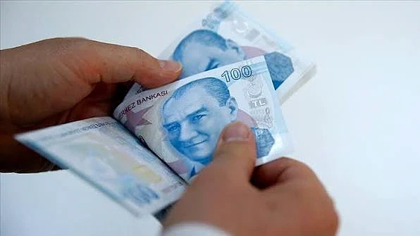 Asgari ücretle çalışan hakları hakkında bilmeniz gerekenler Bir kişinin elinde Türk Lirası banknotları, asgari ücretle çalışanların haklarını simgeliyor.