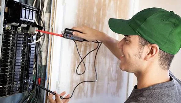 Elektrik iş ilanları ve fırsatları hakkında bilgi Elektrik panosunda çalışan bir elektrikçi, ölçüm aletleri ile elektrik kontrolü yapıyor.